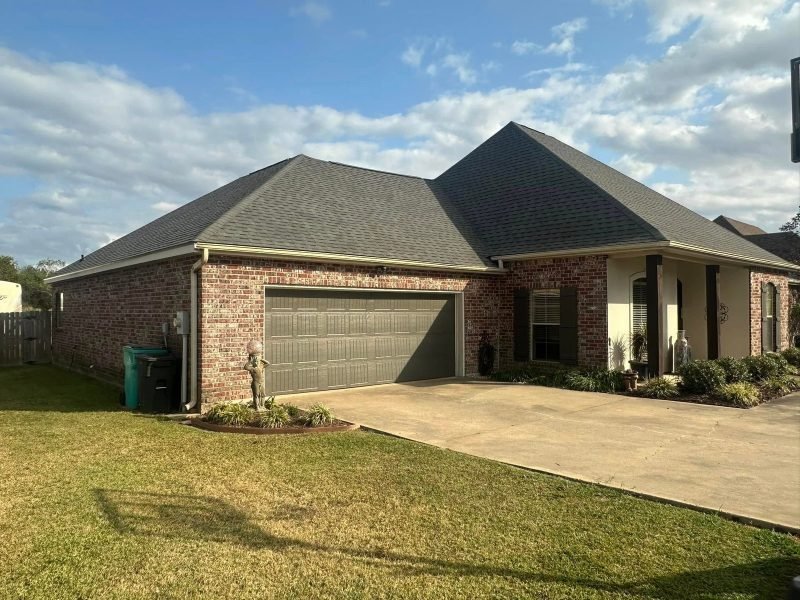 Brick home with a new gray roof and a double garage on a sunny day