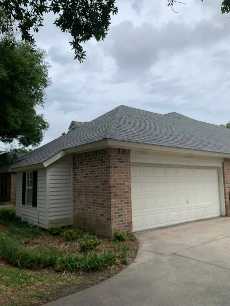 Brick and siding garage wing with a new gray shingle roof