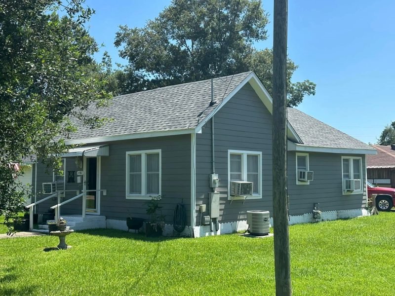 Small cottage with gray lap siding, white trim and a new gray shingle roof